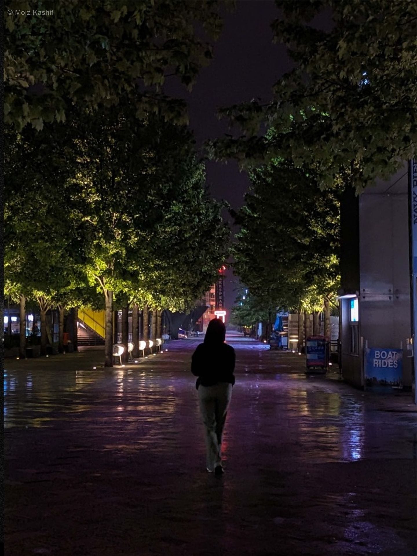 A figure crossing a wet nighttime promenade in the third Mental Health frame.